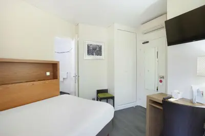 Un ou plusieurs lits dans un hébergement de l'établissement Hotel Gabriel Issy Paris